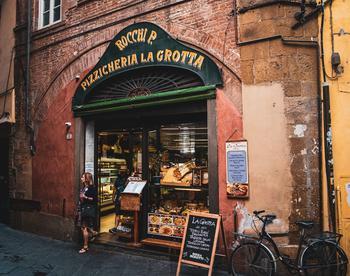 The image shows a restaurant (Pizzicheria), located in Lucca, Italy.